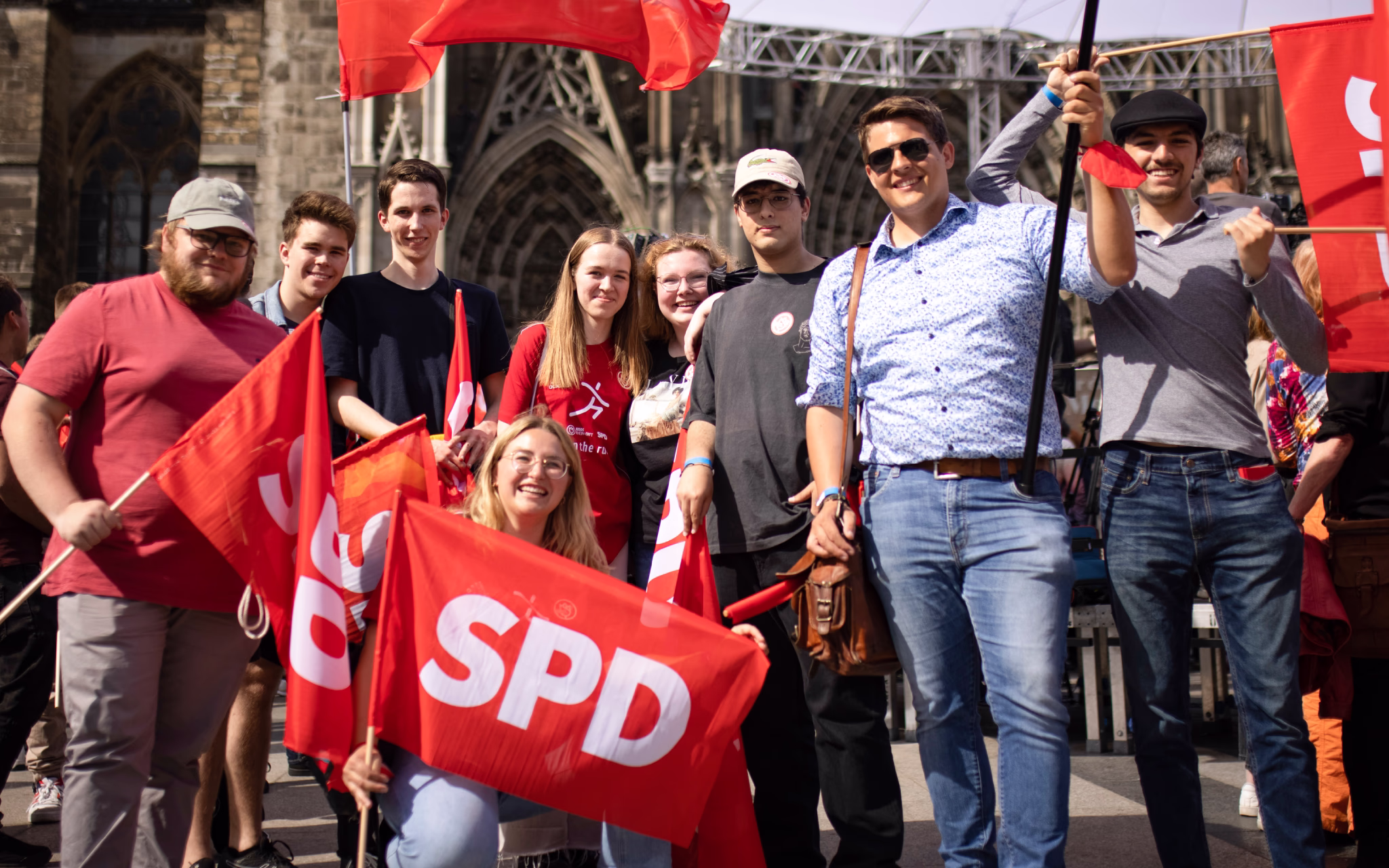 Foto verschiedener Personen mit SPD Flaggen, Shirts und Bannern.