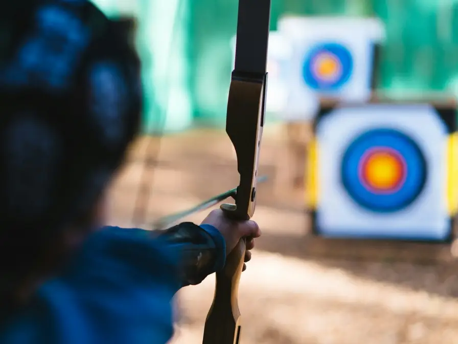 Foto von einer Frau die mit einem Bogen schießt